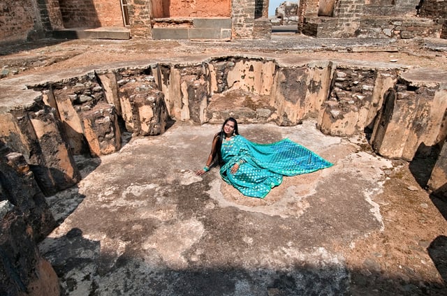 Artistic portrait of Olga B. Aaron against the stone walls of Tarkash Mahal