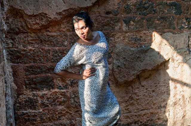 Model Olga B. Aaron posing against the intricate stone archway of Bidar Fort